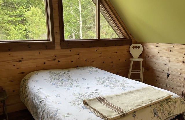 A cozy rustic mountain side cabin with a small river on the property.