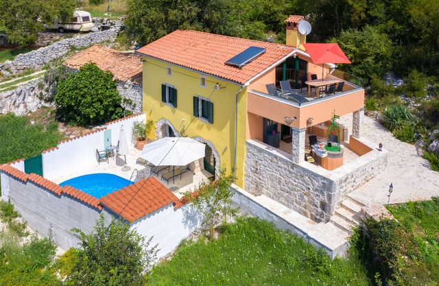 A rustic stone house with pool and sea views.