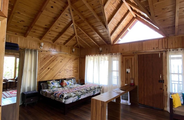 A wooden cottage in an fruits orchard facing Himalayas