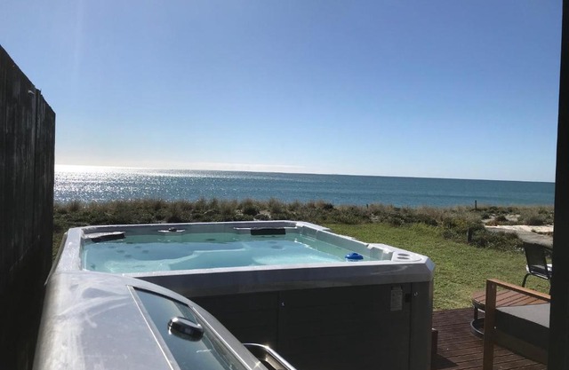 ABSOLUTE BEACHFRONT TINYHOUSE, STUNNING VIEWS, SPA POOL, BBQ, FREE WIFI AND SKY TV!!