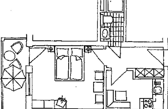 Apartamento con cocina americana, muebles acogedores y balcón.