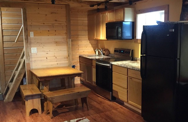 Auténtica casa de troncos de Fairbanks con baño, cocina y porche delantero protegido.