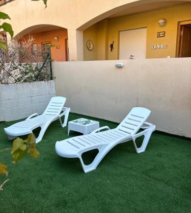 Bajo con jardín a pie de playa y piscina comunitaria con jacuzzi