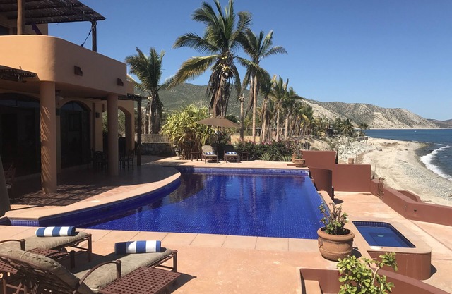 Frente a la playa en la arena con piscina de borde infinito, jacuzzi y playa amigable para los nadadores.