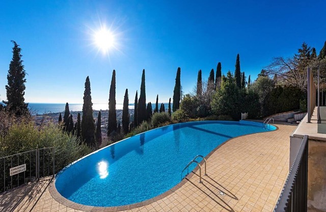 Hermoso apartamento dúplex con jardín privado con vista al Monte Pizzocollo, piscina infinita y una maravillosa vista del lago de Garda