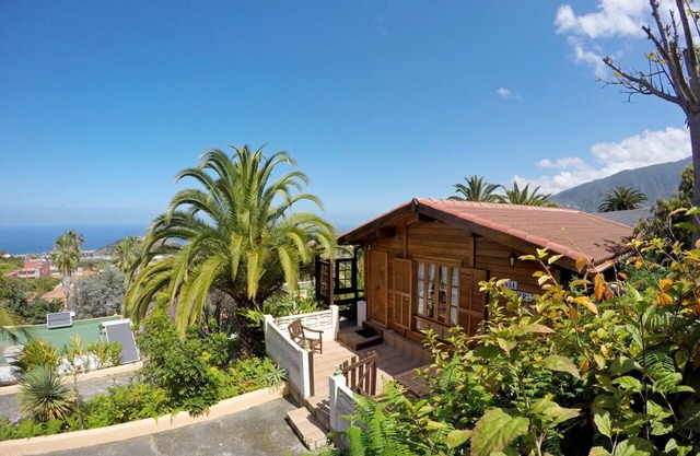 Hermosa casa de madera en una finca tranquila rodeada de palmeras