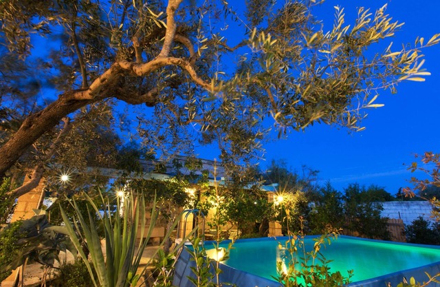 Villa luminosa con piscina rodeada de vegetación cerca del mar.