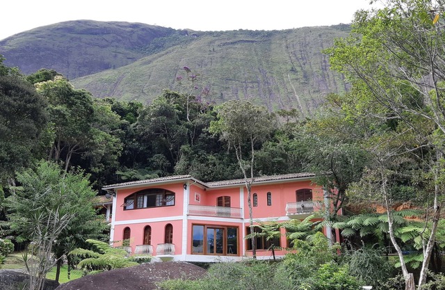 Casa Tico tico das Araras surrounded by mountains in a forest reserve.