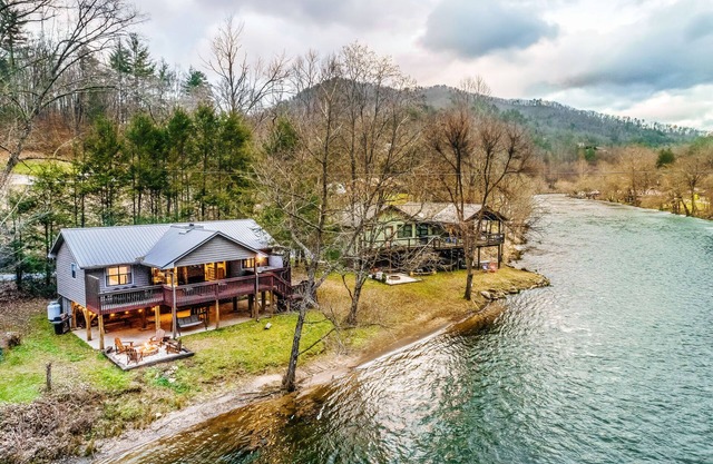 Riverfront getaway with a deck, yard, private hot tub, fireplace, and grill