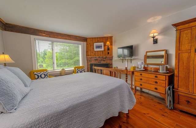 Comfortable, pet friendly room with queen bed, a stunning view of Mount Mansfield, sitting area and a fireplace with full service breakfast included
