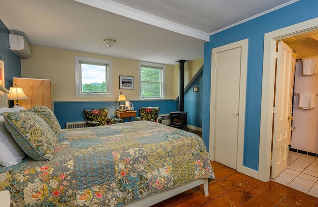 Comfortable room with queen bed, a stunning view of Mount Mansfield, sitting area and a parlor stove with full service breakfast included