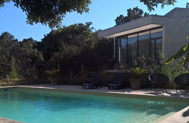 Villa contemporánea en gran jardín mediterráneo con árboles, piscina protegida