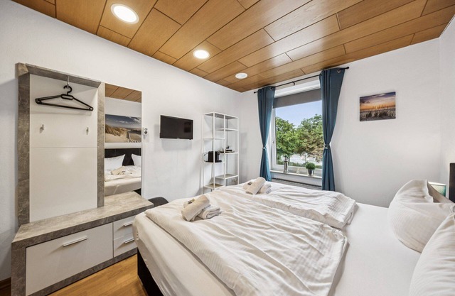 Cozy double room, flat-screen TV, and modern bathroom with shower. Ideal for couples and short stays – enjoy a relaxed atmosphere with warm wood accents and coastal charm.