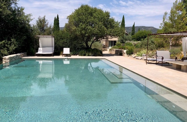 Cortijo de piedra con piscina rodeada de naturaleza, vista panorámica