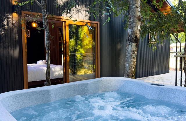 Enarbol Lodge, private hot tube on terrace. High-rise house among trees
