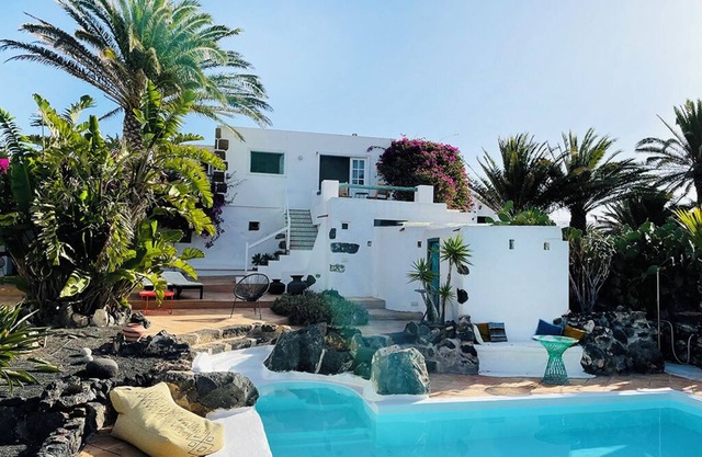 Oasis verde con piscina y vista a las montañas de fuego.