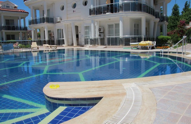 Apartamento en planta baja en un complejo privado con jardines y piscina.