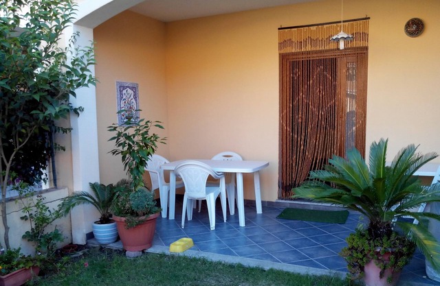 Casa en planta baja con dos pequeños jardines y terraza cubierta.