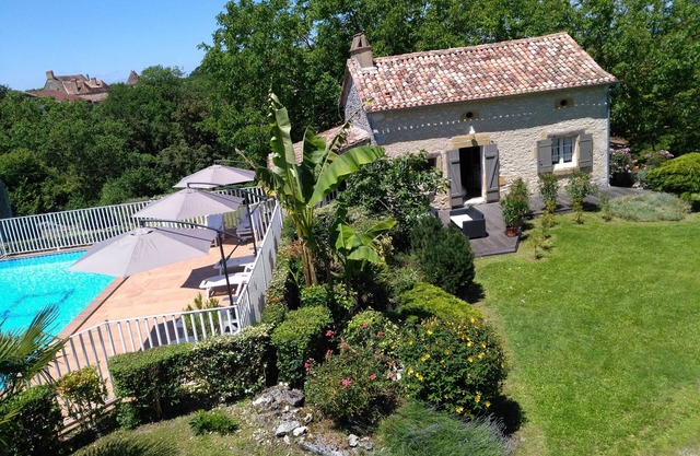 Aldea de 3 casas de piedra alrededor de una piscina.