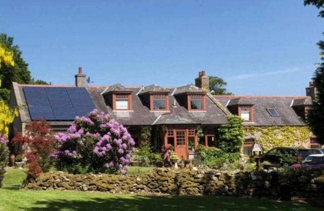 Idyllic countryside haven with lush landscape, manicured garden, pond and stream