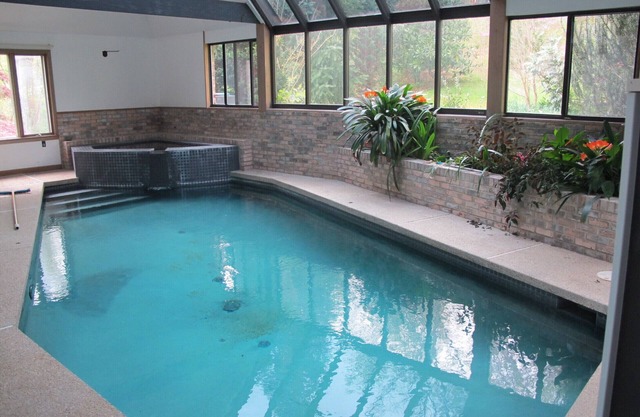 Piscina cubierta y spa en casa francesa contemporánea aislada en los bosques circundantes
