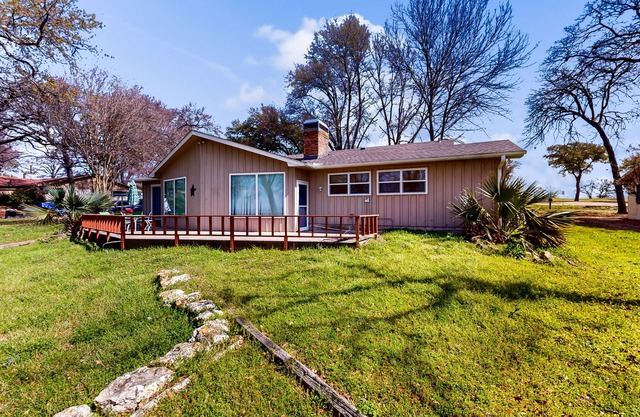 Lakefront retreat near golf course with serene wraparound deck, fireplace, & AC