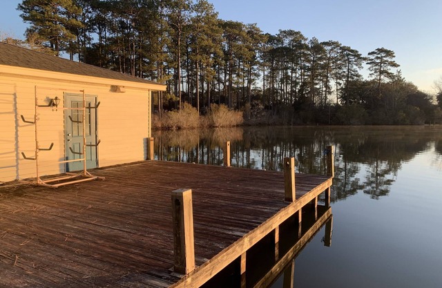 Lakeside pavilion on private lake with a boathouse, outdoor fireplace, kayaks.