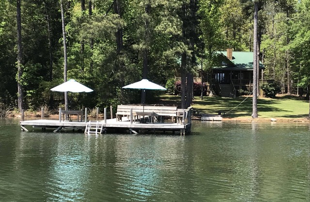 Cabaña grande: cielos azules, hierba verde y vida en el lago