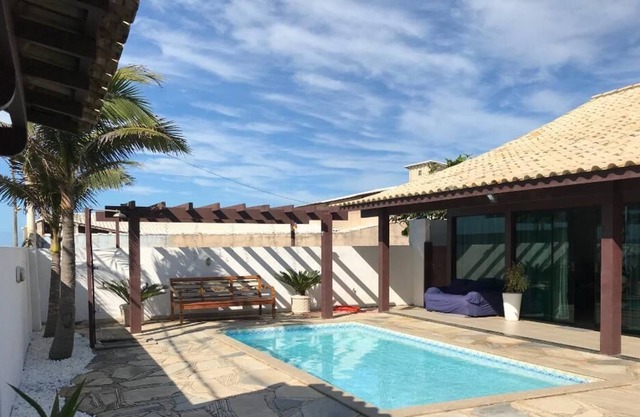 Gran casa de playa moderna con piscina, área de barbacoa, sala de estar y área de relajación.