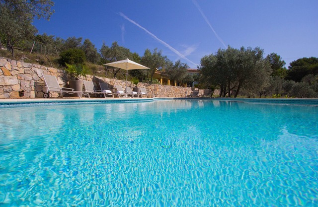 Gran villa con piscina climatizada y vistas impresionantes entre olivos.