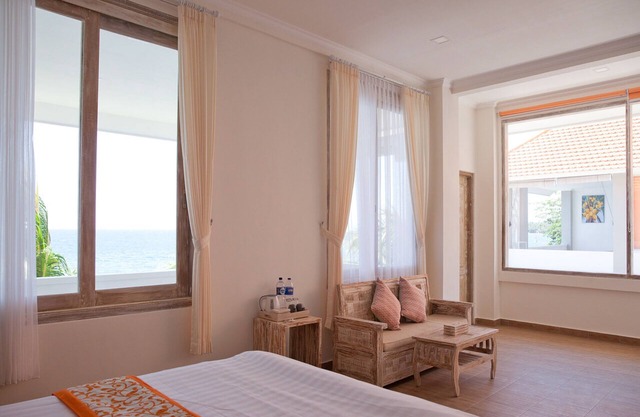 Habitación doble de lujo con bañera con vistas al mar en la terraza.