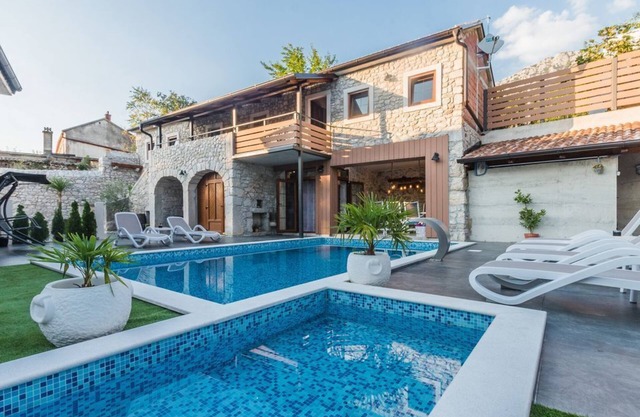 Lujosa villa de piedra con piscina climatizada, piscina infantil y patio en el campo.