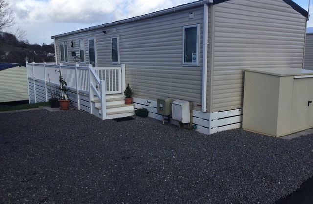 Moderna caravana de 2 camas con terraza y patio circundantes; tiene capacidad para 6 personas