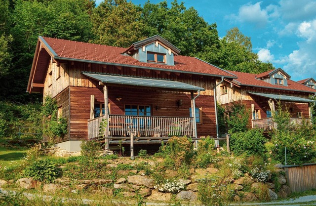 Modern mountain hut with large wooden veranda