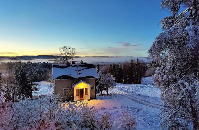 Mysigt hus med utsikt över fjäll och älv.
