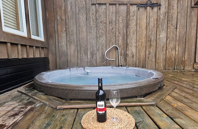 Cozy waterfront cottage, sandy beach front, sunken hot tub, with putting green.
