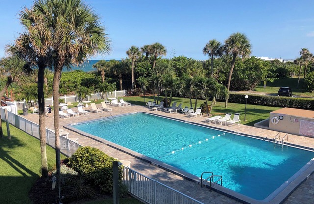 Oceanfront condo with private balcony facing the beach, pool, and CB Pier