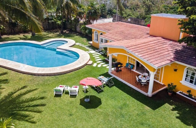 Villa Flores, relaxed family guest home with shared pool near airport.