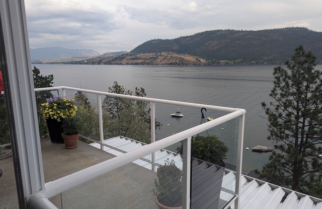 Penthouse Condo with amazing OK lake and mountain views, private beach and dock.