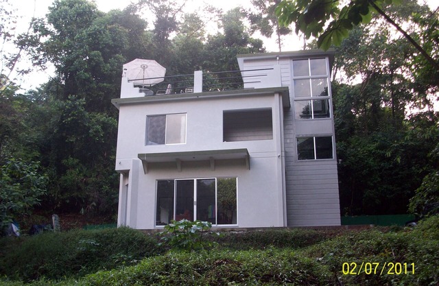 Casa de la selva privada con vista parcial al mar.