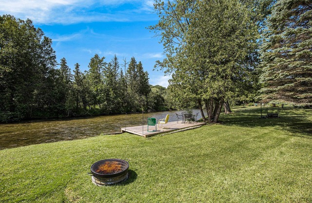 Riverfront cabin with furnished deck, beautiful backyard, firepit & kayaks