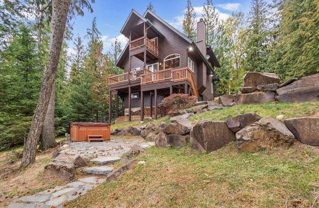 Riverfront home with mountain view, hot tub, deck, WiFi, W/D, & fireplace