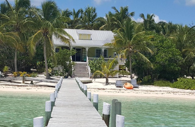 Paraíso frente a la playa de arena con muelle y habitaciones con aire acondicionado en Green Bananas Cottage