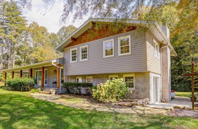 Secluded home on 6 acres with stocked pond, dock, outdoor kitchen, & fireplaces