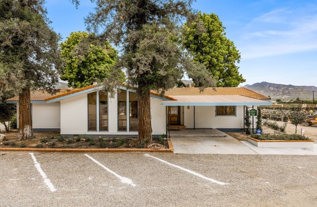 Single-level home surrounded by lush gardens with a washer/dryer, AC, & wet bar