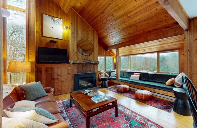 Casa de esquí en el bosque con bañera de hidromasaje privada, chimenea y vistas a la montaña