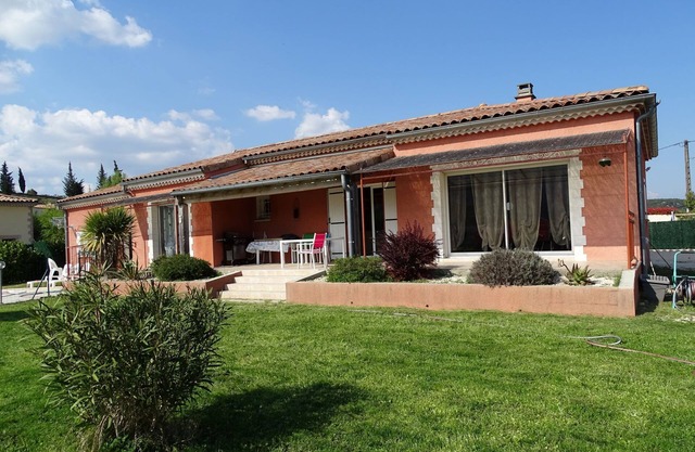 Casa de una planta con piscina y terreno.