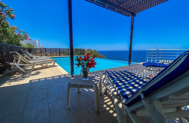 Amplia villa moderna con gran piscina infinita, excelentes vistas al mar mientras se está acostado en la cama