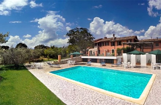 Amplia villa situada entre olivares y amplio jardín con césped y piscina privada.