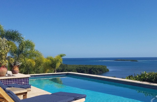 Rainbow Paradise es un 4BR / 3 moderno y arquitectónicamente hermoso. 5 BA casa en un lote de 5 acres con vistas a Manglar y Pela Bays. Muy aislado y privado. A / C en BR, ventiladores de techo, cocina completa, piscina al aire libre con espectacular v...